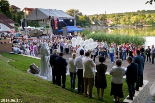 Szoboravat�s. �nnepl� t�meg l�that� a k�pen. A szobor egyel�re lepel alatt van. A h�tt�rben a B�nki-t� �s a v�zisz�npad.