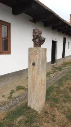 A B�nki menyecske szobra. N�i fejet �br�zol� szobor k�oszlopon. 